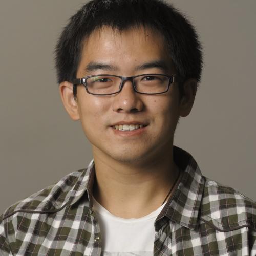 A young man wearing glasses and a plaid shirt.